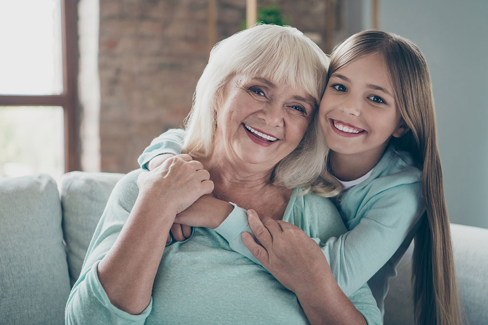 girl hugging grandmother after gum grafting procedure