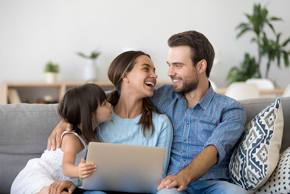 happy family holding laptop at home in ottawa
