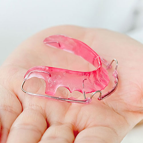 orthodontist holding retainer